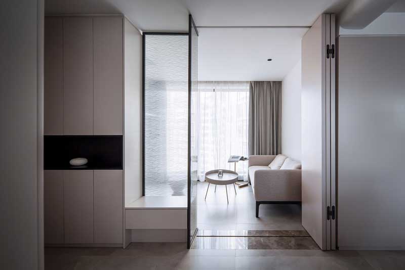 打破原有入戶花園格局限制 重新拆解再利用 利用頂天立地的鞋柜與折疊門結合,磨砂玻璃隔斷下的小臺子兼任換鞋凳的功能,光從磨砂玻璃隔斷透出來,即滿足儲物需求,又為女業主從事地產行業需要在家辦公筑建一個多功能的空間,營造一個開闊又多變的開敞交互的家。 打破原有入戶花園格局限制 重新拆解再利用 利用頂天立地的鞋柜與折疊門結合,磨砂玻璃隔斷下的小臺子兼任換鞋凳的功能,光從磨砂玻璃隔斷透出來,即滿足儲物需求,又為女業主從事地產行業需要在家辦公筑建一個多功能的空間,營造一個開闊又多變的開敞交互的家。